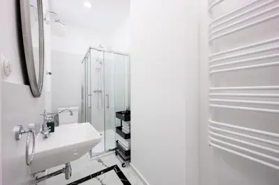 a white bathroom with a sink and a mirror at Native Apartments Dietla 71 in Kraków