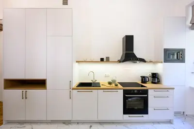 a white kitchen with white cabinets and a stove at Native Apartments Dietla 71 in Kraków
