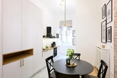a dining room with a black table and chairs at Native Apartments Dietla 71 in Kraków