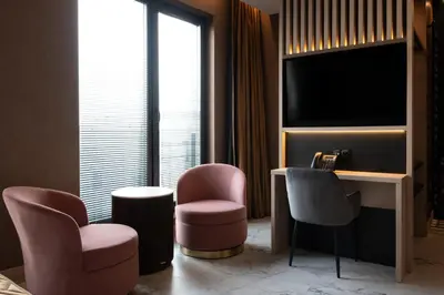 a hotel room with two chairs and a television at Art Suites Luxury Hotel in Kraków