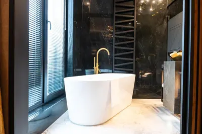 a bath tub in a bathroom with a window at Art Suites Luxury Hotel in Kraków