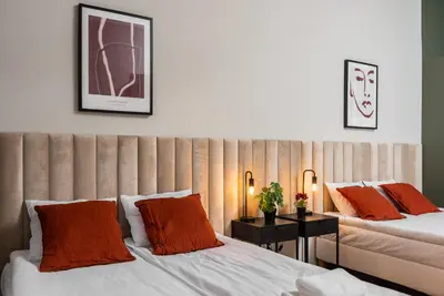 two beds with orange pillows in a room at Przestronny Apartament w Centrum Krakowa - 12 osób - by Upstairs in Kraków