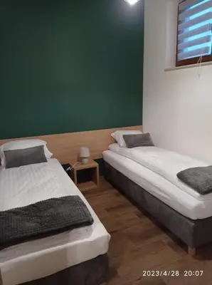 two beds in a room with a green wall at Loft Park Zator, lokalizacja przy wej Parku in Zator