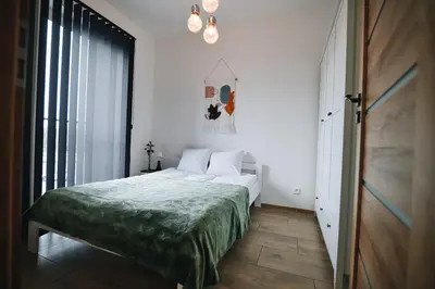 a bedroom with a bed with a green blanket at Apartament 30tka by Housine in Zator
