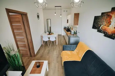 a living room with a couch and a table at Apartament 30tka by Housine in Zator