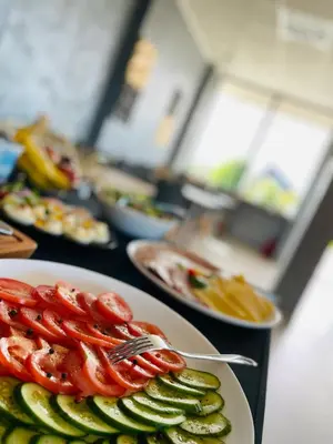 a table topped with plates of food with tomatoes and cucumbers at Apartament 30tka by Housine in Zator