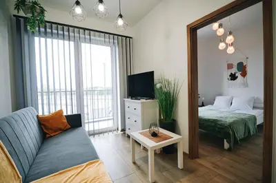 a living room with a couch and a bed and a mirror at Apartament 30tka by Housine in Zator