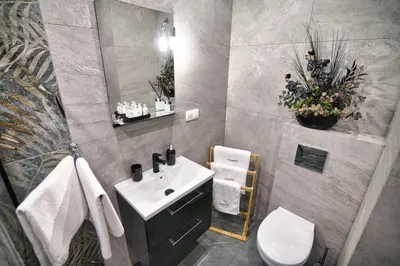 a bathroom with a sink and a toilet and a mirror at Apartament 30tka by Housine in Zator