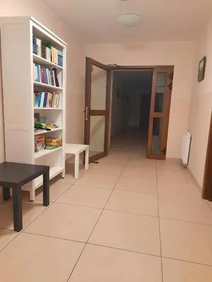 a hallway with a table and a book shelf at Karmelitański Dom Gościnny in Zawoja