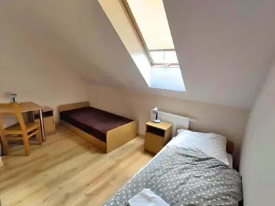 a bedroom with a bed and a desk and a skylight at Karmelitański Dom Gościnny in Zawoja