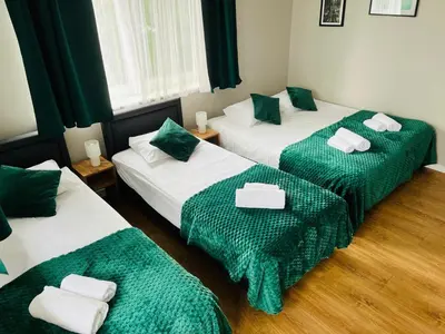 a room with two beds with green and white sheets at Zielony Zakątek Przeciszów Zator in Przeciszów