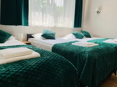 two beds in a room with green and white sheets at Zielony Zakątek Przeciszów Zator in Przeciszów