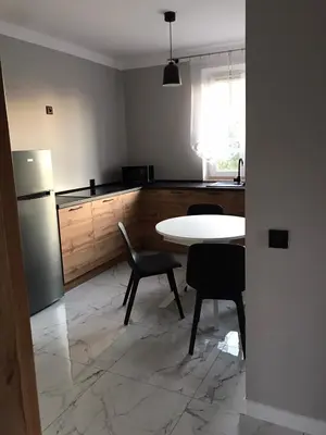 a kitchen with a table and chairs and a refrigerator at Zielony Zakątek Przeciszów Zator in Przeciszów