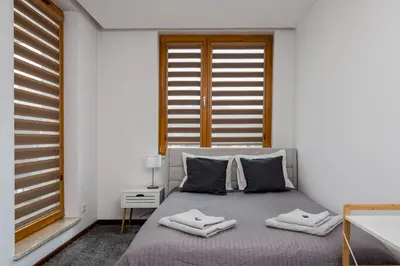 a bedroom with a bed with two towels on it at Superior Apartment with Terrace & Free Parking in Kraków