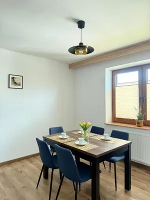 a dining room with a table and blue chairs at Apartamenty Wadowity- Energylandia Zator in Wadowice