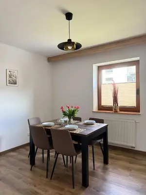 a dining room with a table and chairs and a window at Apartamenty Wadowity- Energylandia Zator in Wadowice