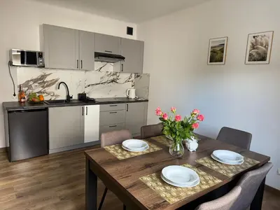 a kitchen and dining room with a table and chairs at Apartamenty Wadowity- Energylandia Zator in Wadowice