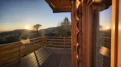 a view from a porch of a cabin with the sun setting at Pacygówka in Skawica