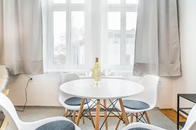 a white dining room with a white table and chairs at Miodowa Kazimierz Apartment in Kraków