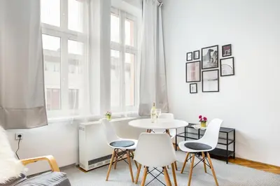 a white living room with a table and chairs at Miodowa Kazimierz Apartment in Kraków