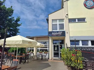 a restaurant with tables and umbrellas in front of a building at Bagry Rooms3 LoveKrakow in Kraków