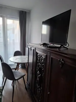 a television on top of a wooden cabinet with a table at Bagry Rooms3 LoveKrakow in Kraków