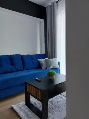 a blue couch in a living room with a table at GOOD PLACE Zator in Zator